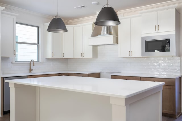 kitchen featuring white cabinets, a kitchen island, stainless steel dishwasher, and sink