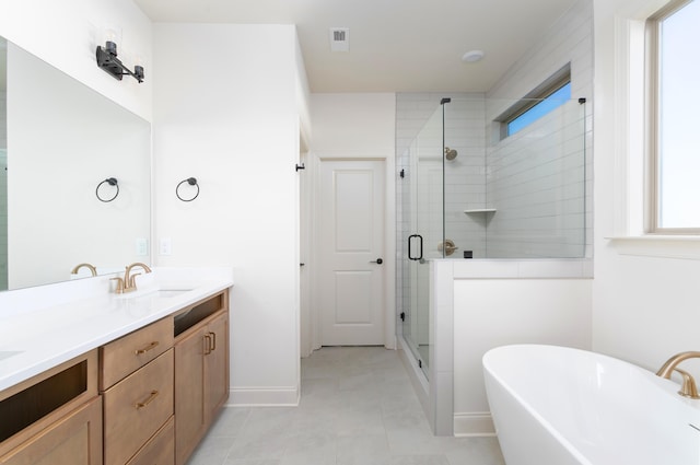 bathroom with tile patterned floors, vanity, and shower with separate bathtub