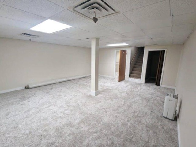 basement featuring carpet and a drop ceiling