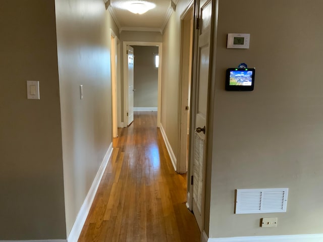 hall with hardwood / wood-style flooring and ornamental molding