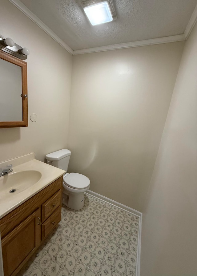 bathroom with vanity, toilet, ornamental molding, and a textured ceiling