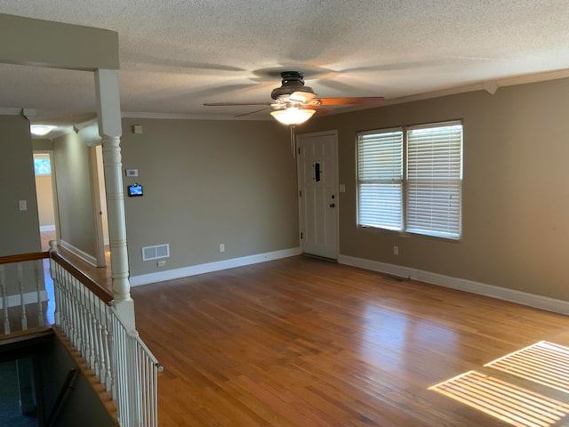 interior space featuring hardwood / wood-style flooring, ceiling fan, crown molding, and a textured ceiling