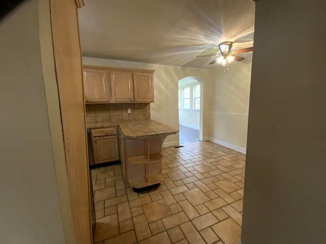 kitchen with ceiling fan, light brown cabinets, tasteful backsplash, a kitchen breakfast bar, and tile countertops