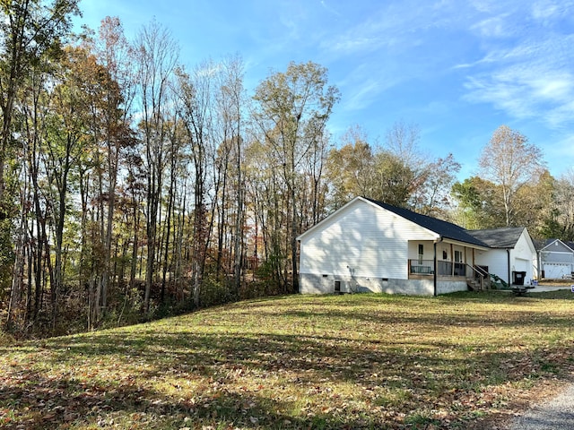 view of home's exterior featuring a lawn, a porch, and a garage