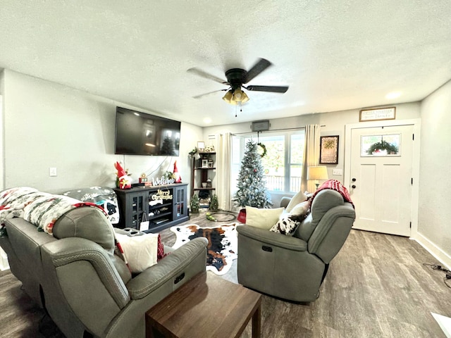 living room with a textured ceiling, light hardwood / wood-style flooring, and ceiling fan