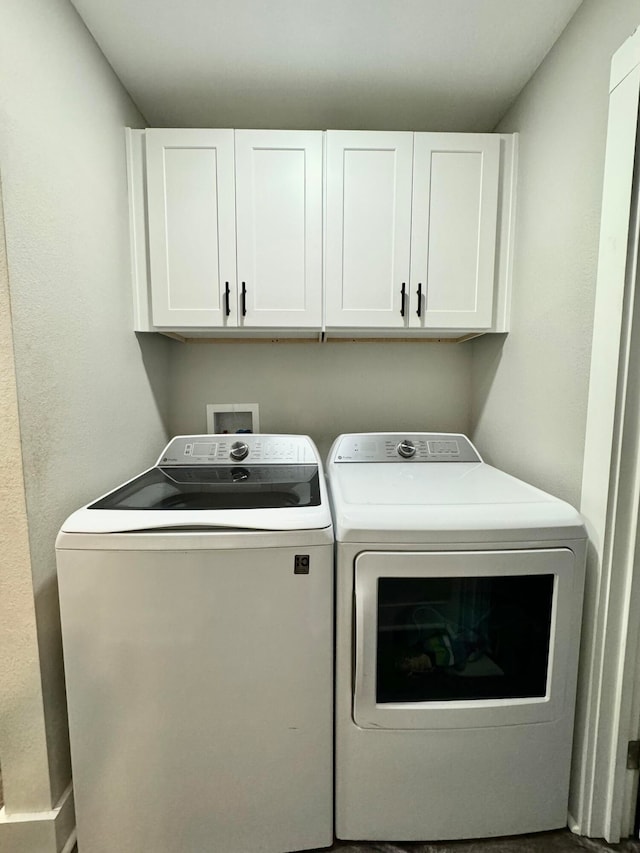 laundry area with washer and dryer and cabinets