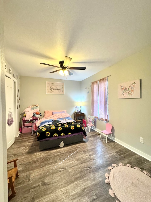 bedroom with dark hardwood / wood-style flooring and ceiling fan