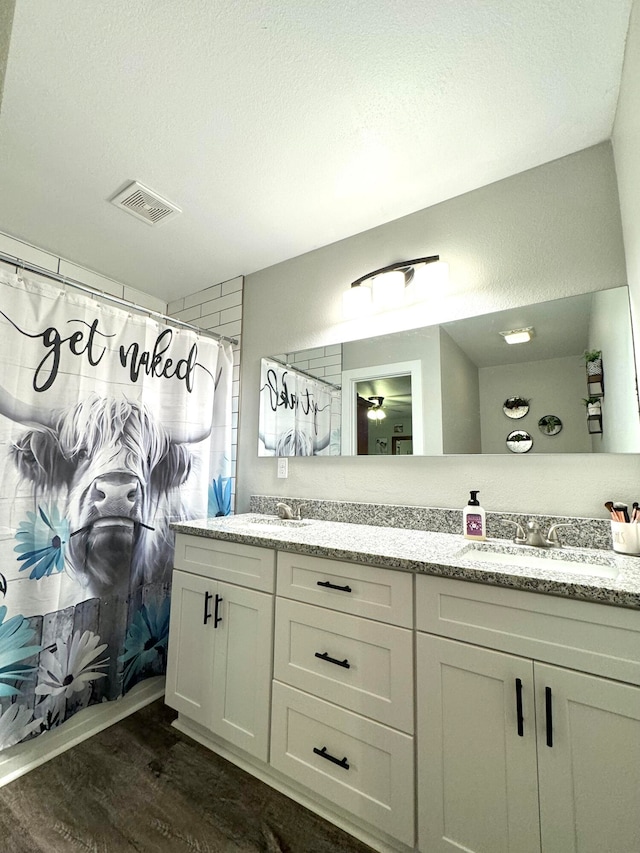 bathroom featuring a shower with curtain, vanity, a textured ceiling, and hardwood / wood-style flooring