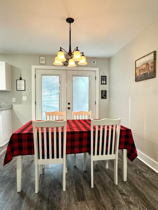 dining area featuring dark hardwood / wood-style flooring, a chandelier, and french doors