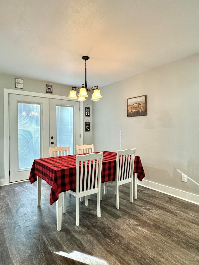 dining space featuring french doors, dark hardwood / wood-style floors, and a notable chandelier