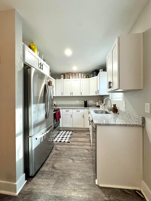 kitchen featuring light stone counters, sink, white cabinets, and appliances with stainless steel finishes