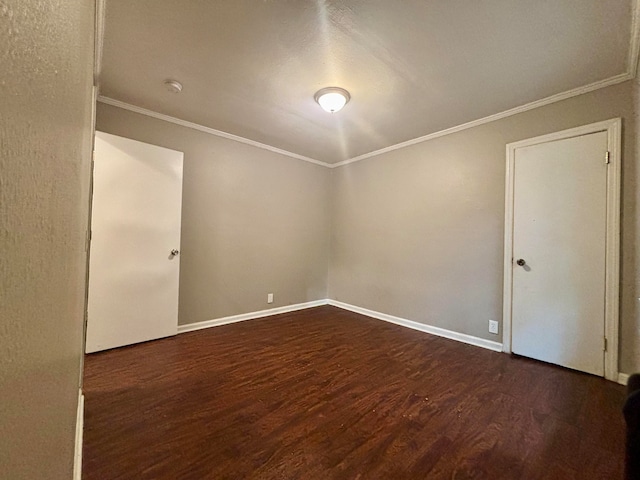 empty room with dark hardwood / wood-style flooring and ornamental molding