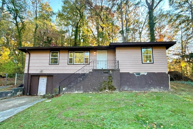 view of front of property featuring a garage, driveway, a front lawn, and stairs