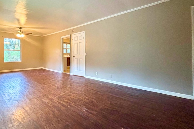 unfurnished room featuring ornamental molding, ceiling fan, dark wood-type flooring, and baseboards