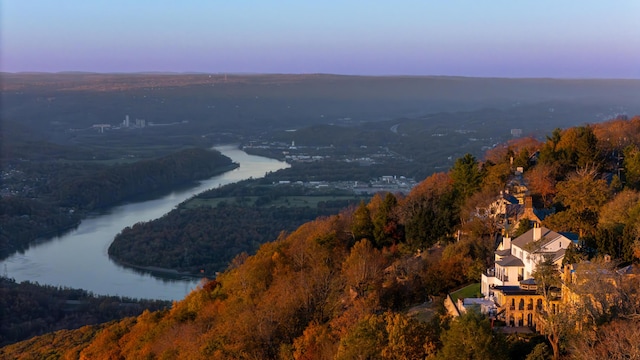 aerial view at dusk featuring a water view