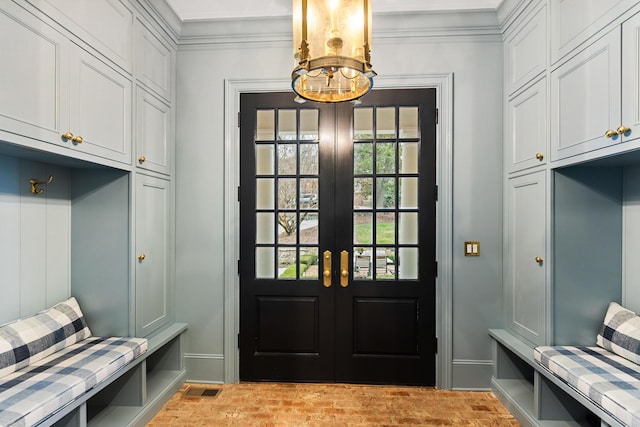 mudroom featuring crown molding, french doors, and a chandelier