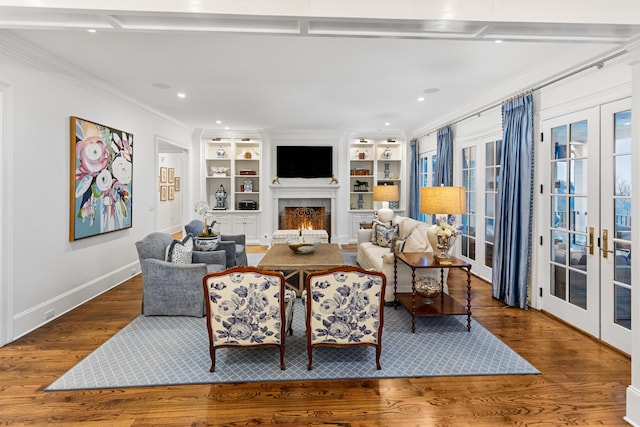 living room featuring built in features, wood-type flooring, crown molding, and french doors