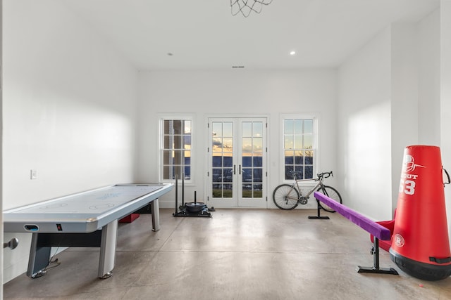 game room featuring french doors and concrete flooring