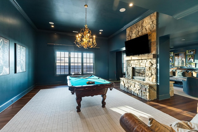 rec room with dark wood-type flooring, an inviting chandelier, billiards, ornamental molding, and a fireplace