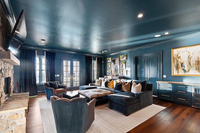 home theater room with a fireplace, ornamental molding, french doors, and dark wood-type flooring