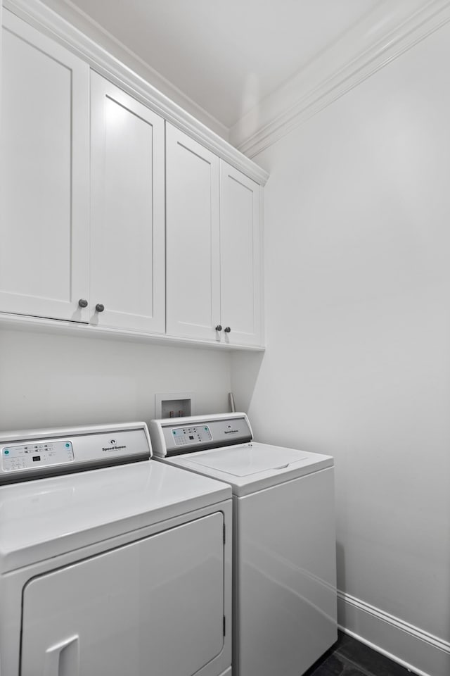 washroom featuring washer and dryer, cabinets, and ornamental molding