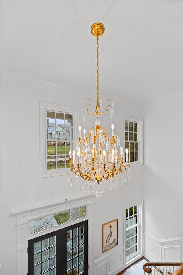 room details featuring french doors, ornamental molding, and a notable chandelier