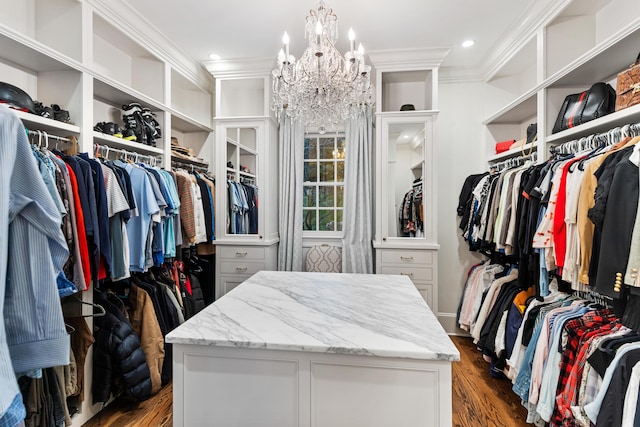 spacious closet with a chandelier and dark wood-type flooring