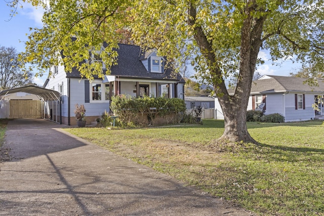 cape cod house featuring a front lawn, a porch, and a carport