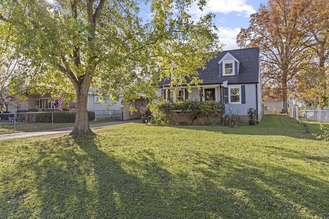 cape cod home featuring a front yard