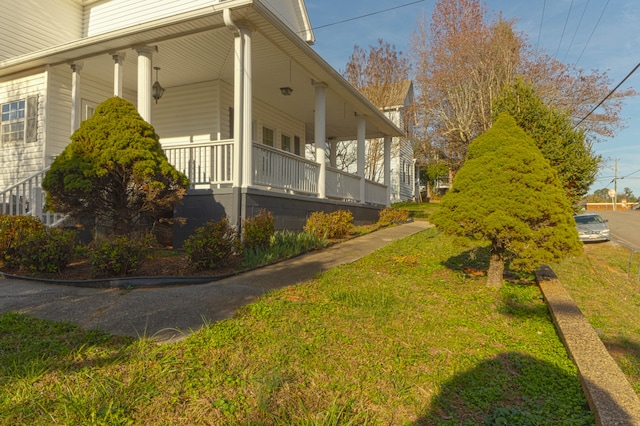 view of home's exterior with a lawn and a porch