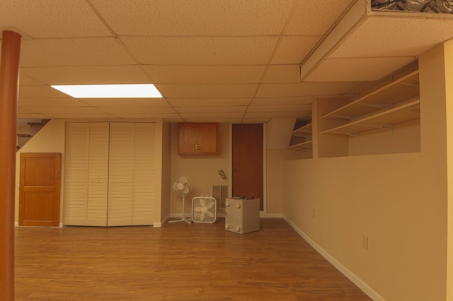 basement featuring hardwood / wood-style floors and a drop ceiling