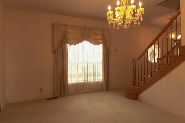 unfurnished living room with carpet flooring and an inviting chandelier