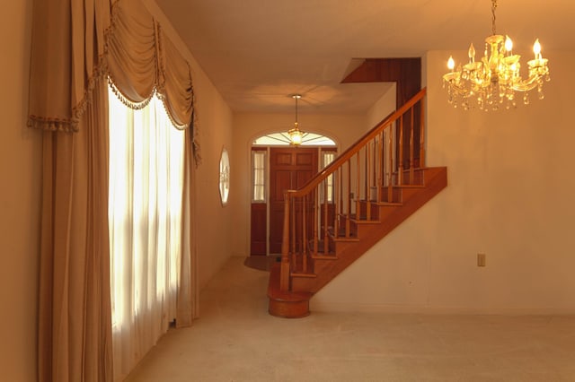 stairs with a notable chandelier and carpet floors