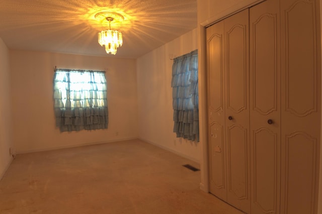 interior space with light carpet and an inviting chandelier