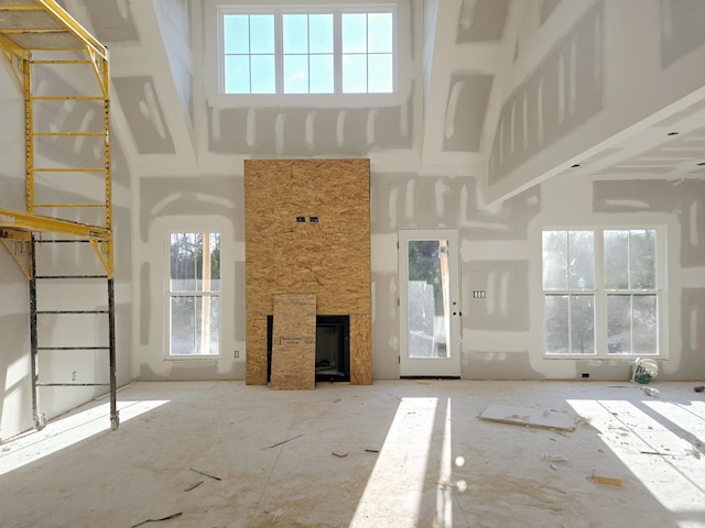 unfurnished living room with a towering ceiling and a fireplace