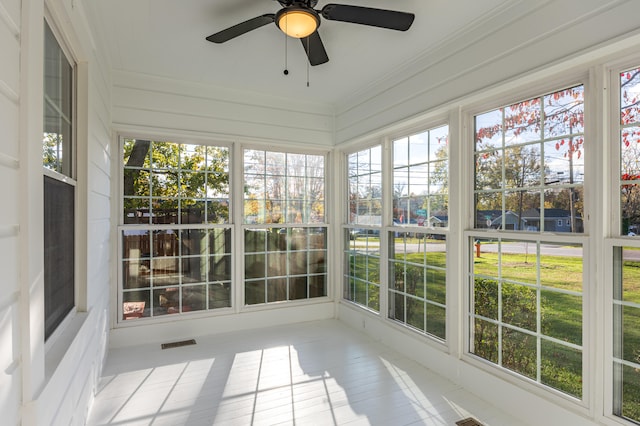 unfurnished sunroom featuring ceiling fan