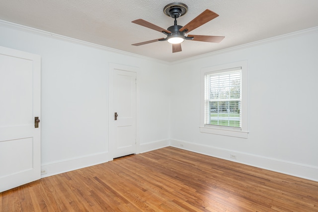 spare room featuring hardwood / wood-style floors, a textured ceiling, and ornamental molding