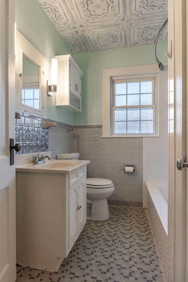 bathroom with vanity, tile walls, and toilet