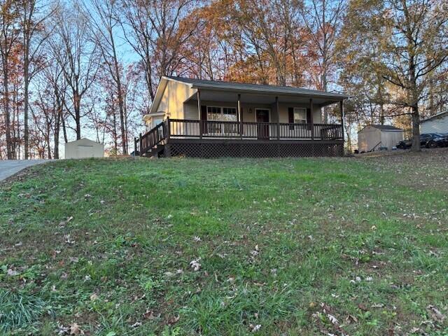 view of front of property with a front lawn and a storage shed