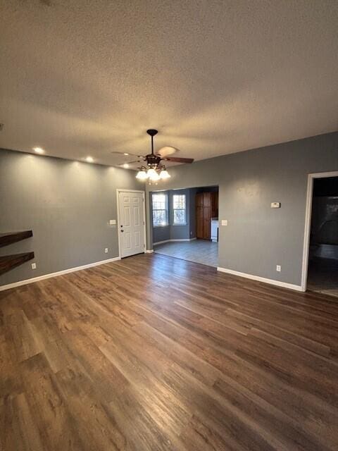 unfurnished living room with ceiling fan, dark hardwood / wood-style flooring, and a textured ceiling