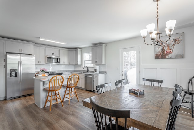 dining room featuring hardwood / wood-style floors, sink, and an inviting chandelier