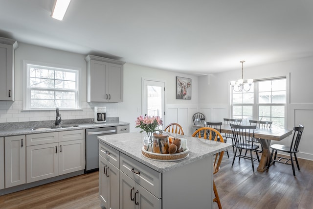 kitchen featuring sink, pendant lighting, dishwasher, a center island, and dark hardwood / wood-style floors