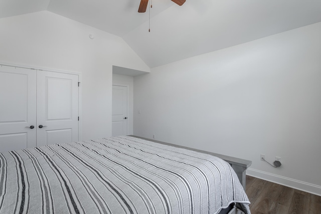 bedroom with ceiling fan, a closet, dark wood-type flooring, and vaulted ceiling