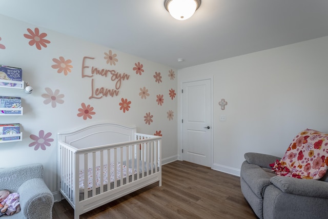 bedroom featuring dark hardwood / wood-style flooring and a crib