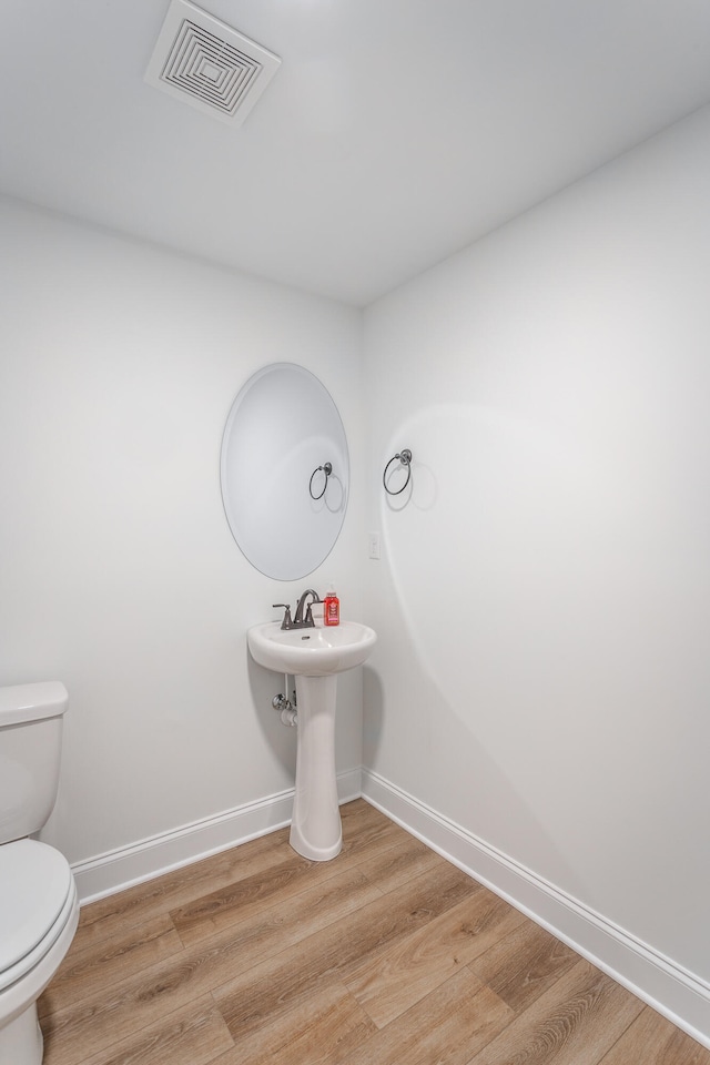 bathroom featuring hardwood / wood-style floors and toilet