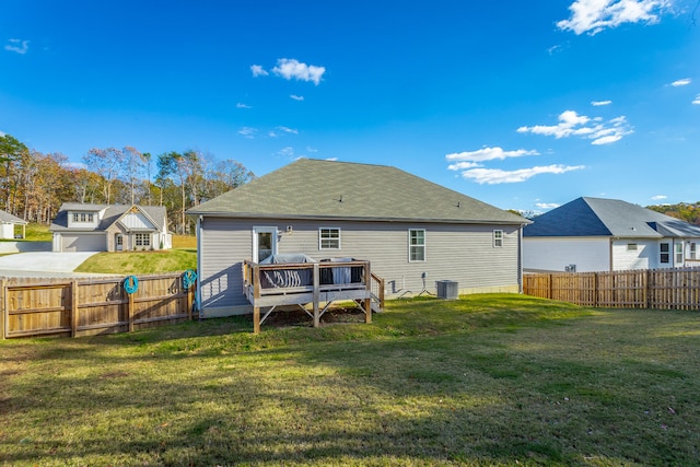 rear view of house with a lawn, a wooden deck, and cooling unit