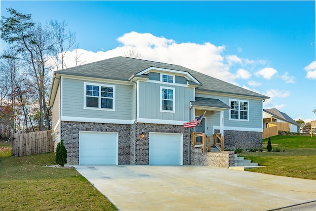 bi-level home featuring a garage and a front lawn