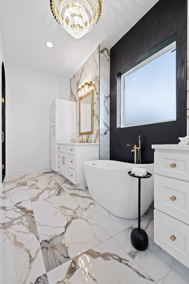 bathroom featuring a notable chandelier, a washtub, wooden walls, and vanity