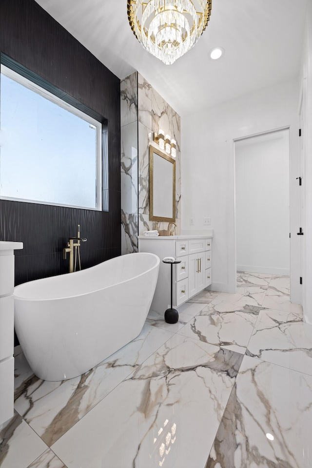 bathroom with a tub, wooden walls, vanity, and an inviting chandelier