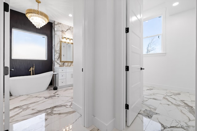 bathroom featuring a bathtub, vanity, and a notable chandelier